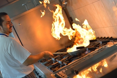 chef cooking with flames from pan