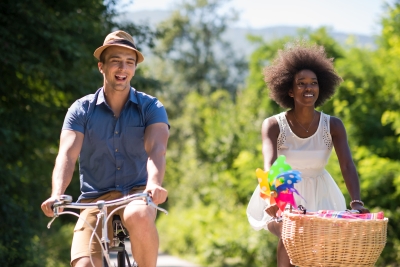 white man and black woman riding bikes in nature